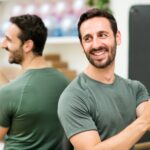 Emotional first aid for sadness cheerful fit man holding trx tape at gym lxzaewu