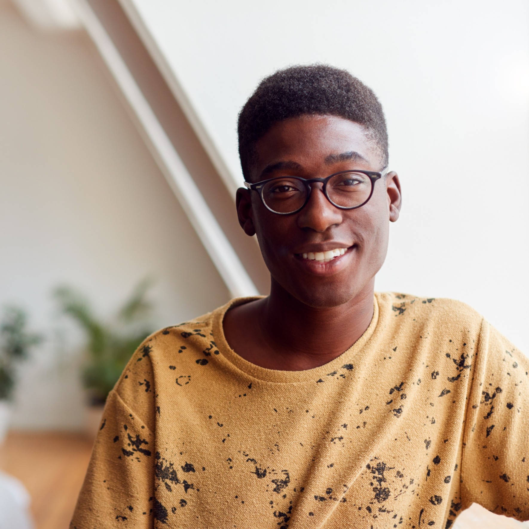 Home portrait of smiling young man in loft apartment d86kmzp.jpg